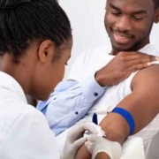 African american male having his blood drawn by a nurse in a doctor's office.