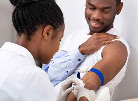 African american male having his blood drawn by a nurse in a doctor's office.