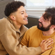 Two men in their living room in loving embrace