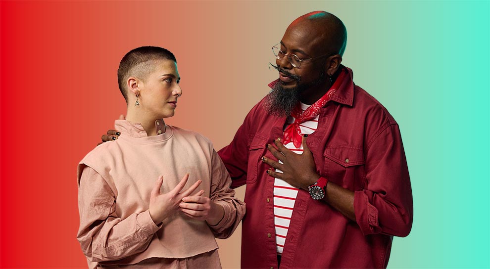 Two people stand against a black background, engaging in a heartfelt conversation. The person on the left, in pink, and the person on the right, in red, share a sincere moment.